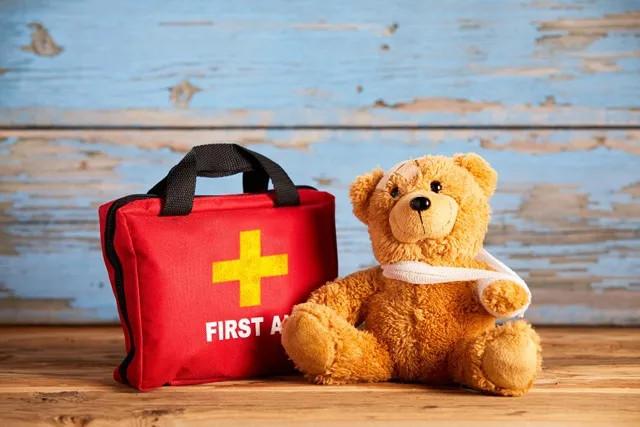 a first aid kit and a bandaged stuffed animal