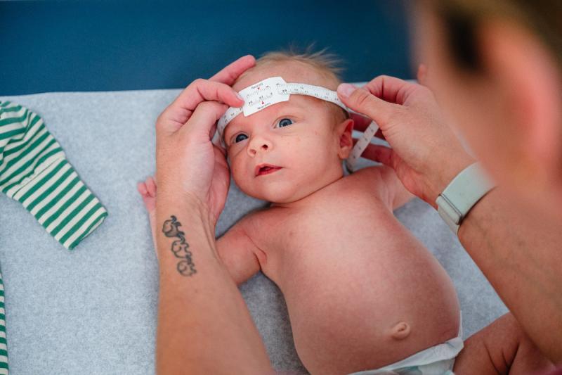 a newborn baby getting its head measured